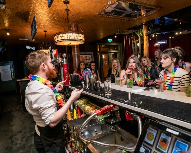 people watching  bartender behind the bar on a cocktail masterclass at revolucion de cuba