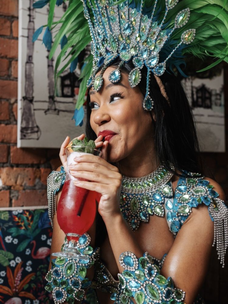 a lady dressed in rio carnival dress enjoying a cocktail on a tapas and cocktails experience at revolucion de cuba