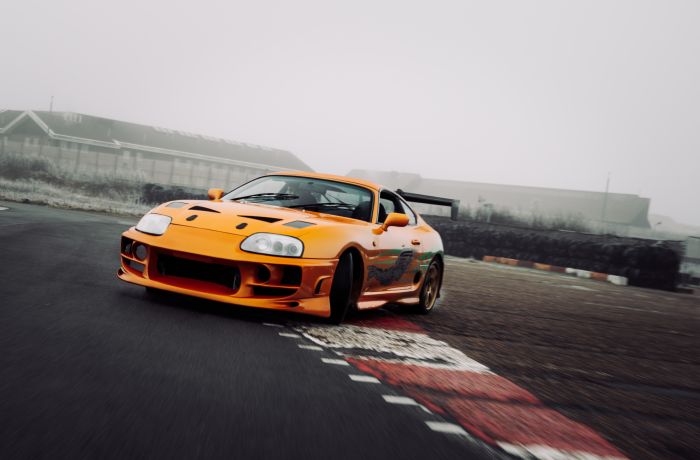 an orange toyota supra on the track for a drift legends driving experience day