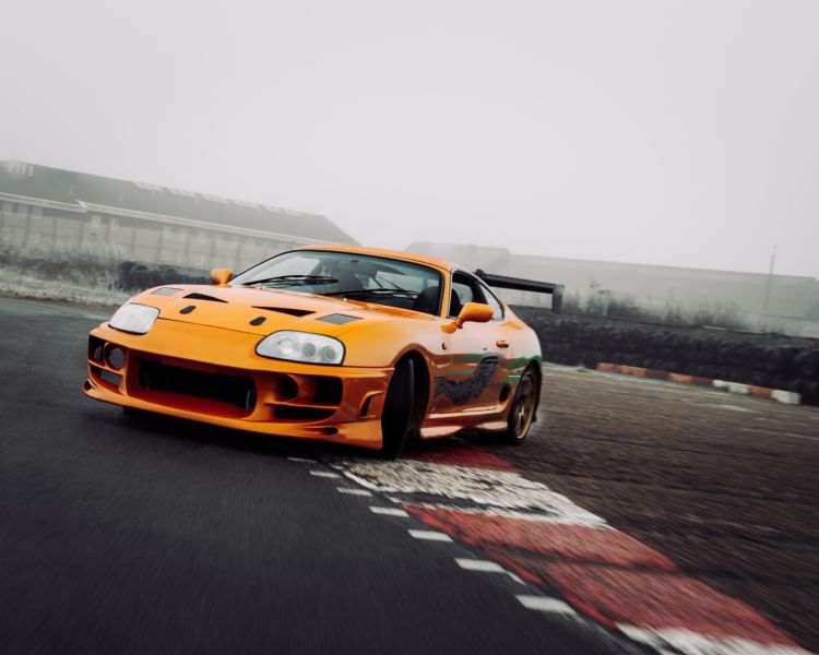 an orange toyota supra on the track for a drift legends driving experience day