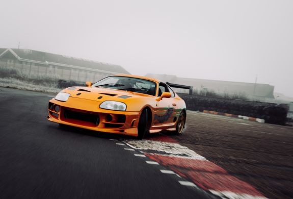 an orange toyota supra on the track for a drift legends driving experience day