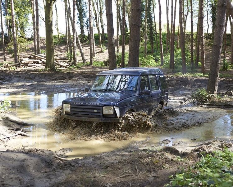 a landrover going through water on a woodland course on an off road driving experience