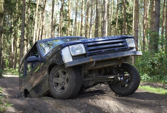 a landrover going up a bank on a woodland course on an off road driving experience