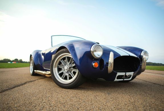 a close up of the front of a vintage sports car on a track as part of a driving experience day