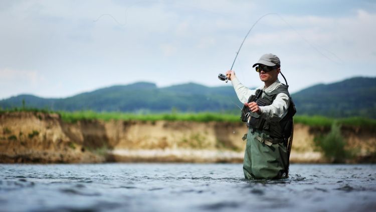 A man fly fishing in a lake