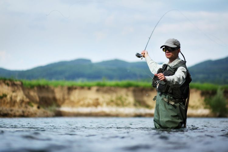 A man fly fishing in a lake