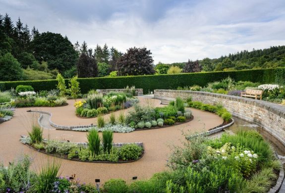 the cool garden at rhs rosemoor in devon with planting separated by gravel paths