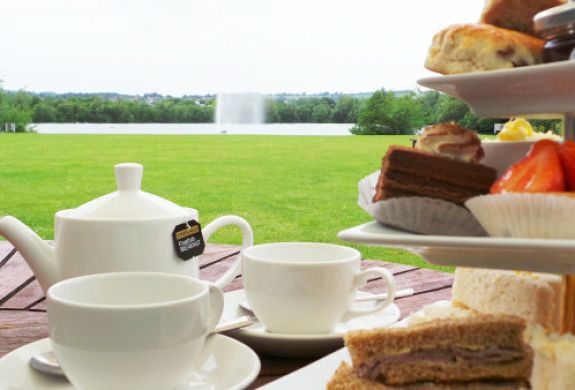 afternoon tea set up on a table outside in the gardens of the crown plaza hotel