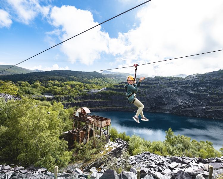 young girl on the zip world quarry flyer zip line going over the quarry