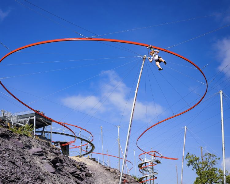 person on the zip world aero explorer going around one of the loops