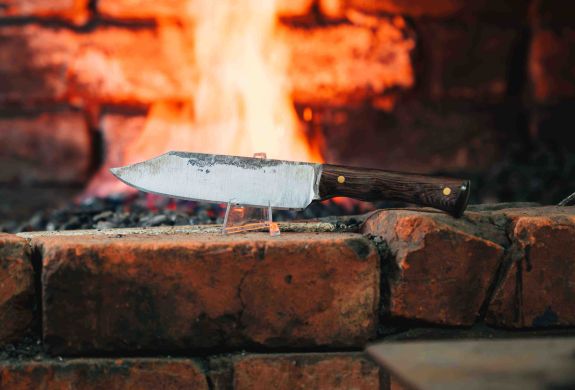a knife in front of a fire made on a knife making and handling experience