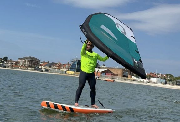 man wingsurfing on the water on a learn to wingsurf experience