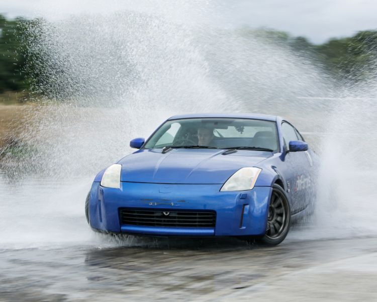 blue sports car drifting through water