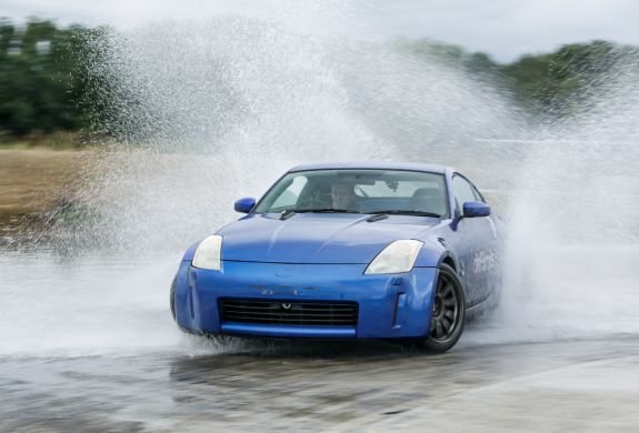 blue sports car drifting through water