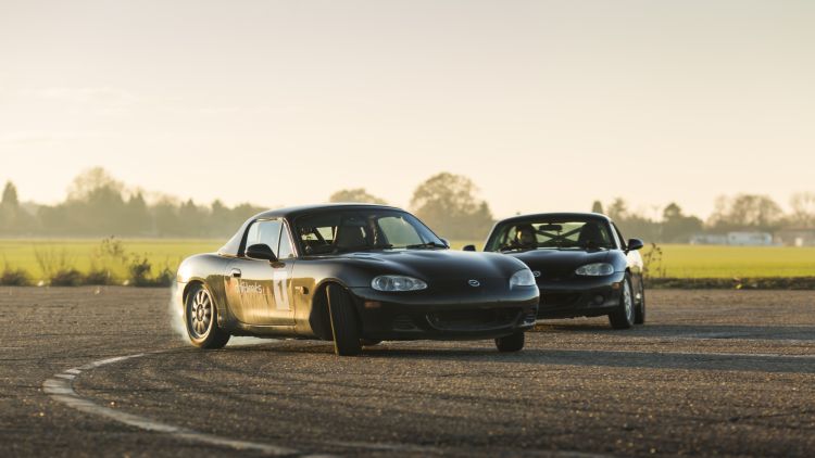 2 black cars sports cars on a track as part of a drifting experience day