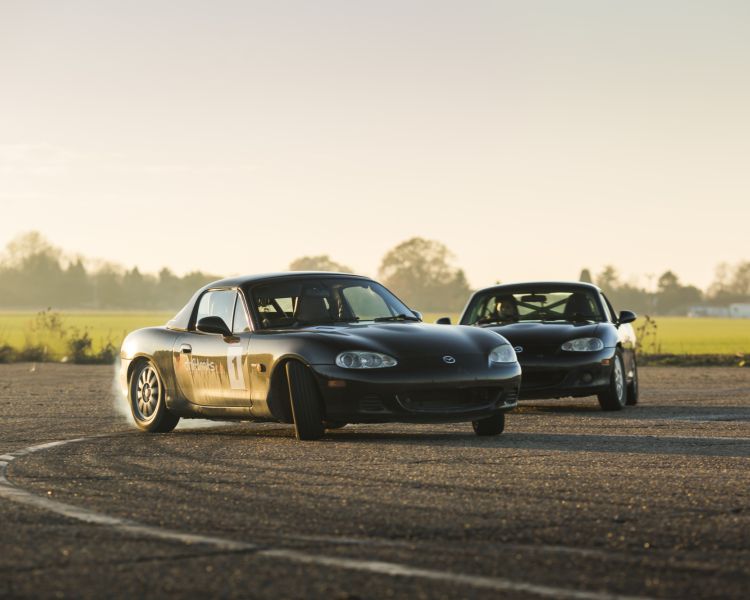 2 black cars sports cars on a track as part of a drifting experience day