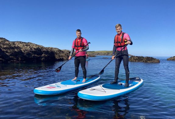 2 men paddleboarding in the sea