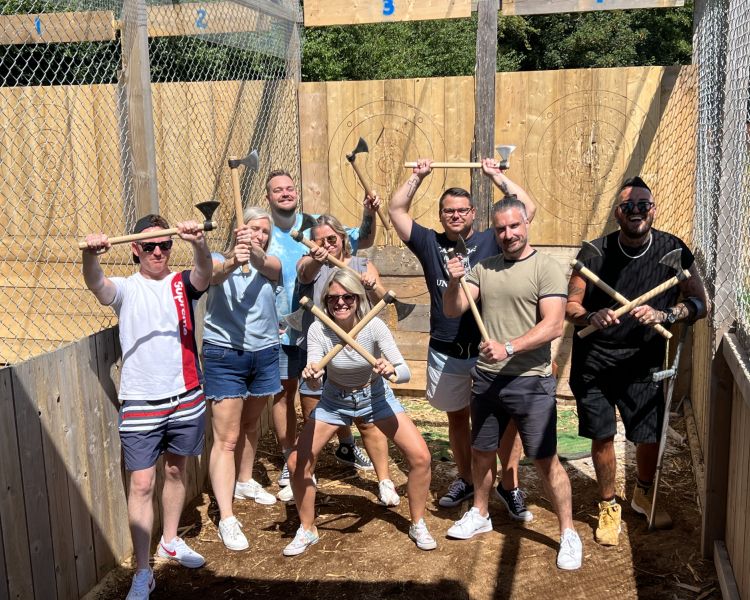 group of people posing for photo holding axes on an axe throwing experience in tunbridge wells in kent