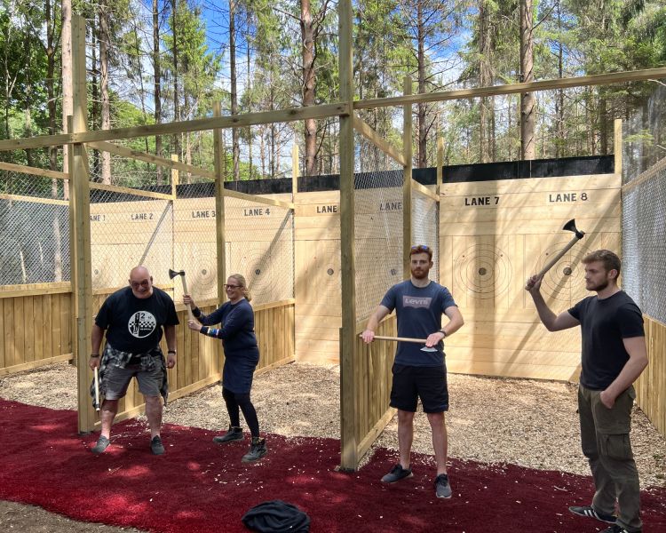 four people posing for photo holding axes on an axe throwing experience in tunbridge wells in kent