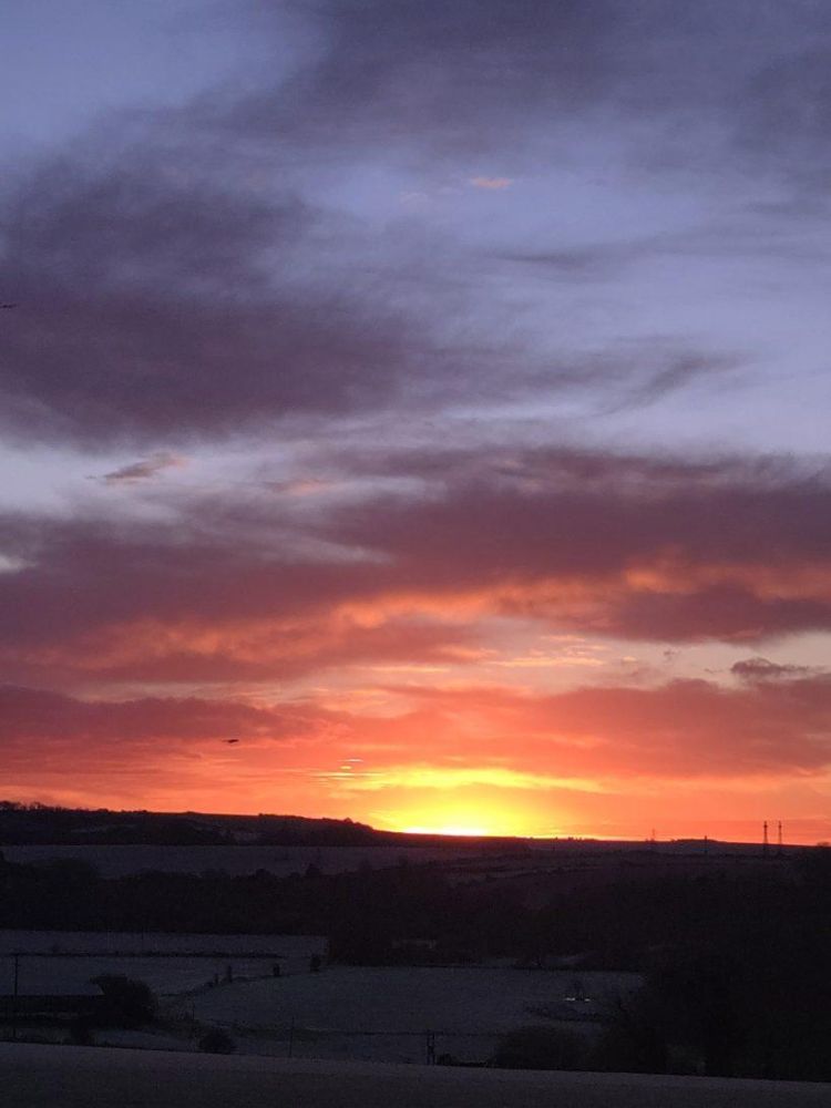 a sunrise seen from a glamping pod on a stonehenge unique stay
