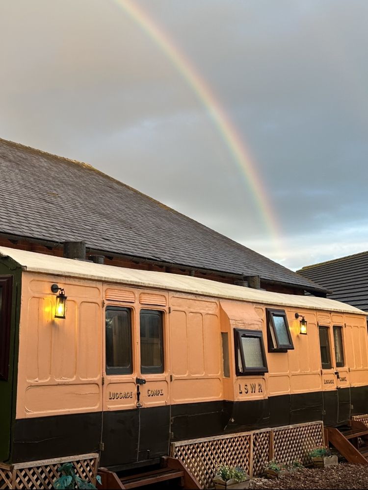 The front of the railway carriage with rainbow in the sky above