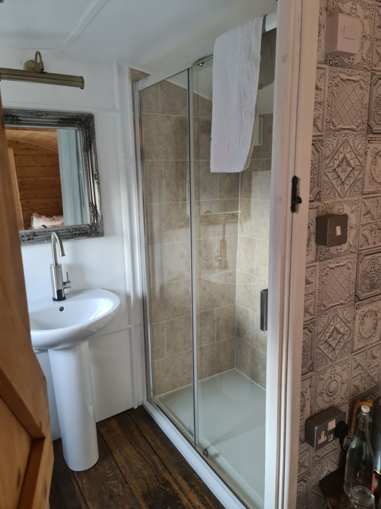 The bathroom with shower inside the railway carriage used for short stays near stonehenge