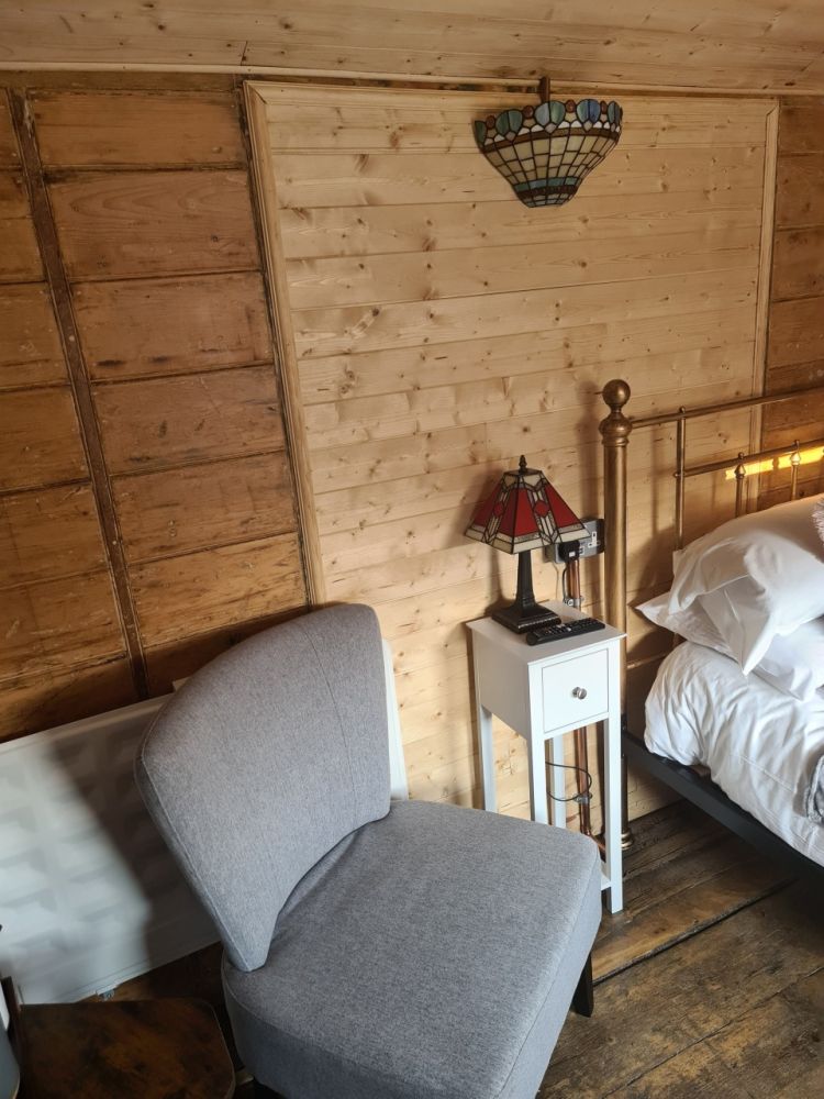 The seating area next to the bed inside the railway carriage used for short stays near stonehenge