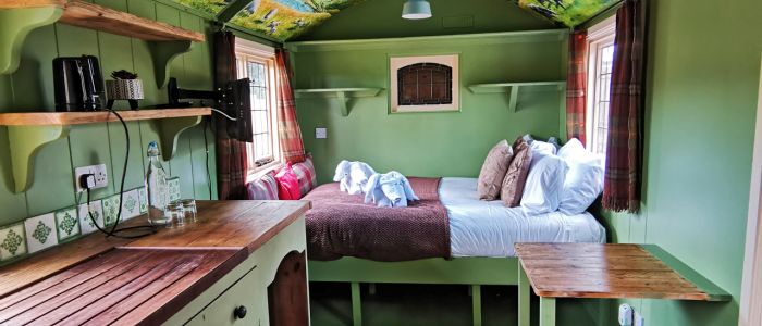 Looking at the bed area from the kitchen inside the shepherds hut used for short stays near stonehenge