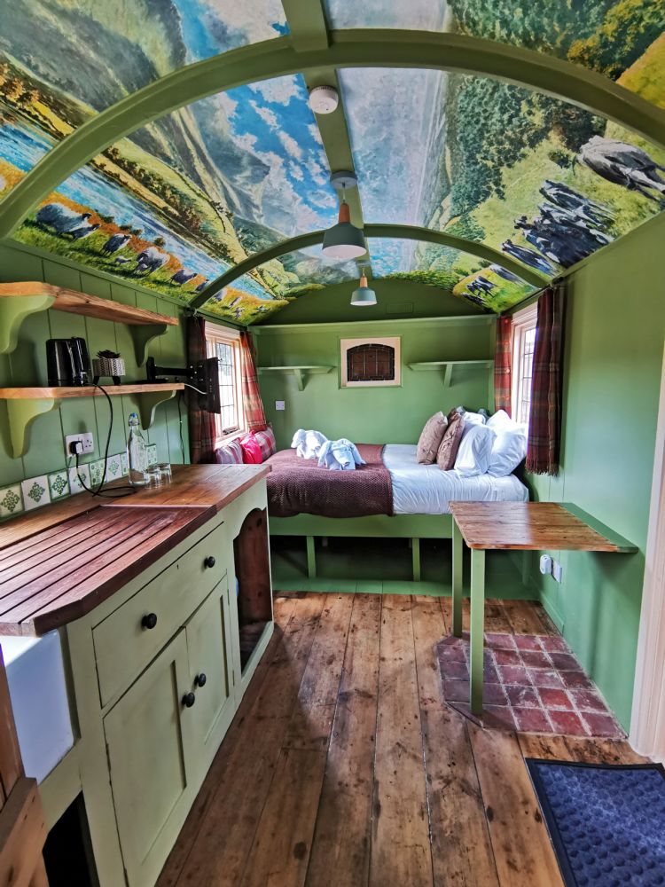 Looking at the bed area from the kitchen inside the shepherds hut used for short stays near stonehenge