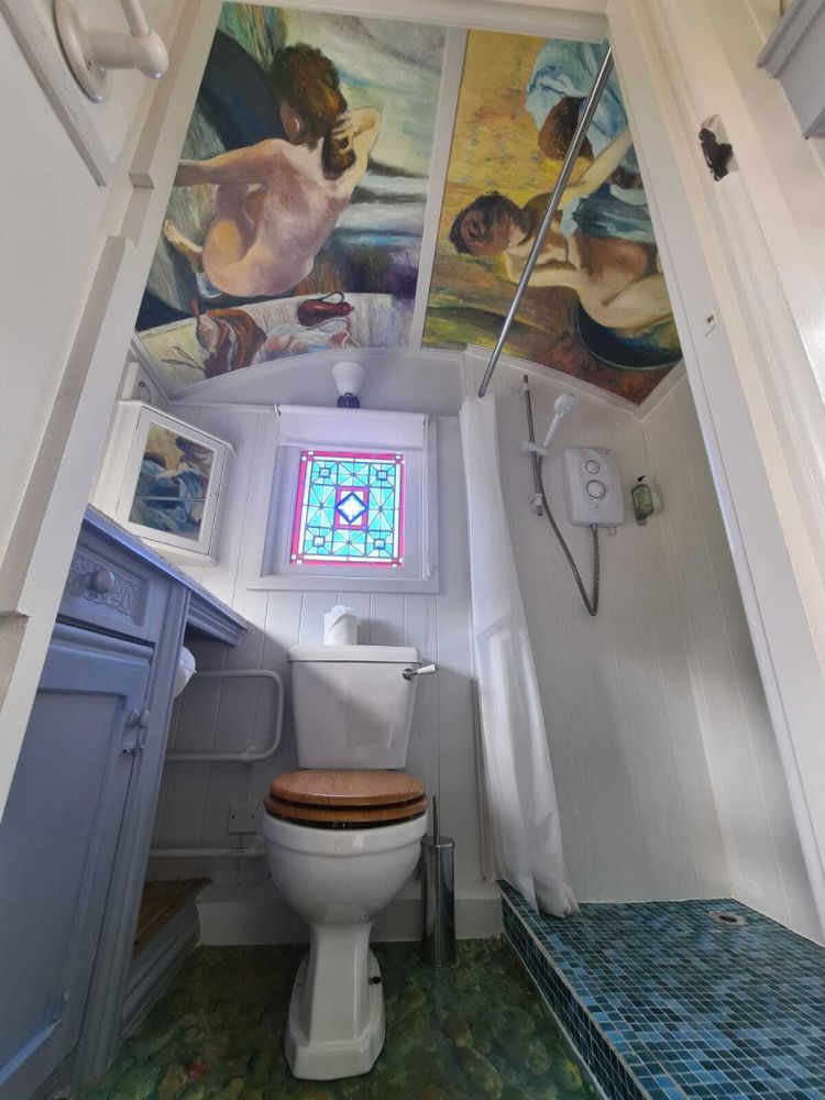 The bathroom with toilet and shower inside the shepherds hut used for short stays near stonehenge