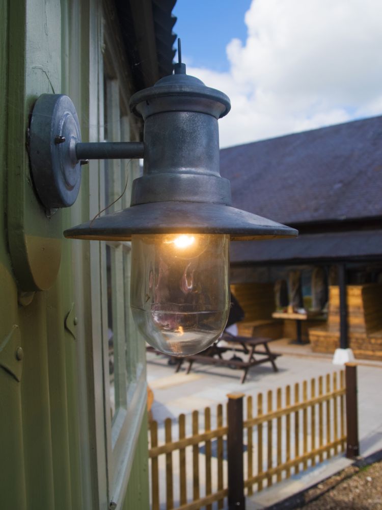 The outside light on the shepherds hut looking towards the pub patio area