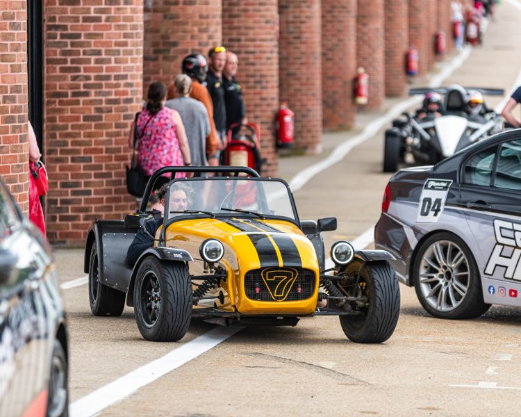 a caterham seven in the pit lane ready to go out on the track for a driving experience