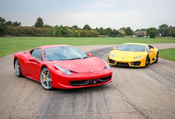 a red ferrari and a yellow lamborghini on a race track for a driving experience day