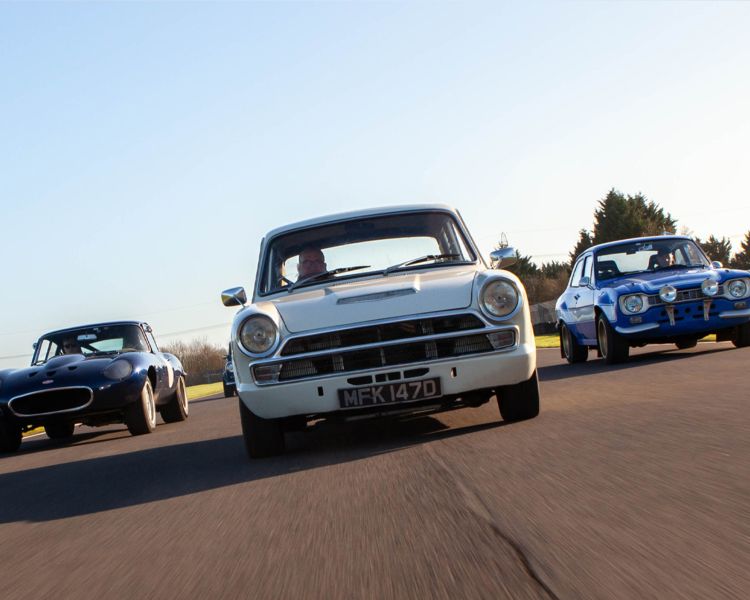 three classic cars on a race track for a supercar vs classic car driving experience