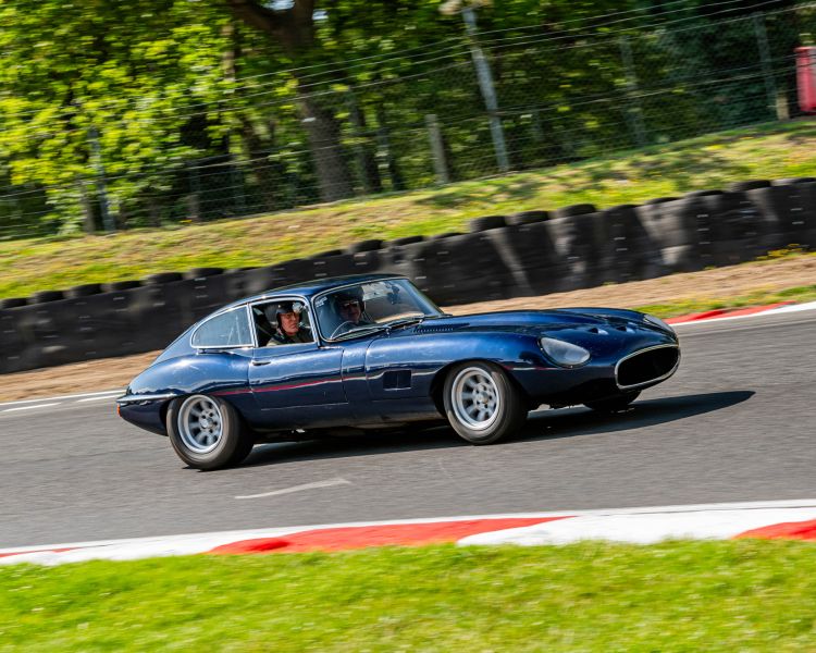 a dark blue classic car on a race track for a supercar vs classic car driving experience