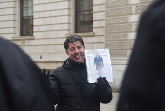 Guide holding photo of movie scene seen on a spy movie film locations walking tour in london