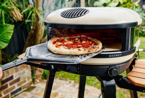 pizza making in an outdoor pizza oven at cookery class