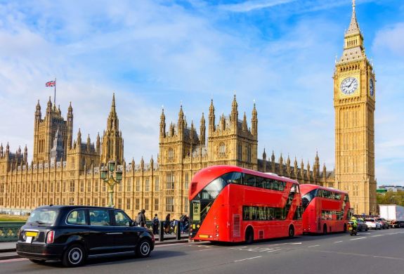 Houses of parliament and big ben with black cab and red buses in front