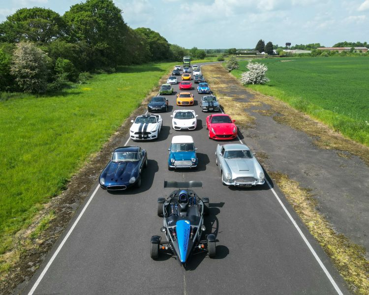 an aerial shot of multiple sports cars lined up on a race track as part of an all stars track day experience