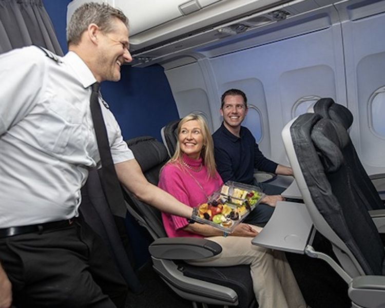 couple being served a light lunch in the cabin of a boeing 737 flight simulator at luton airport