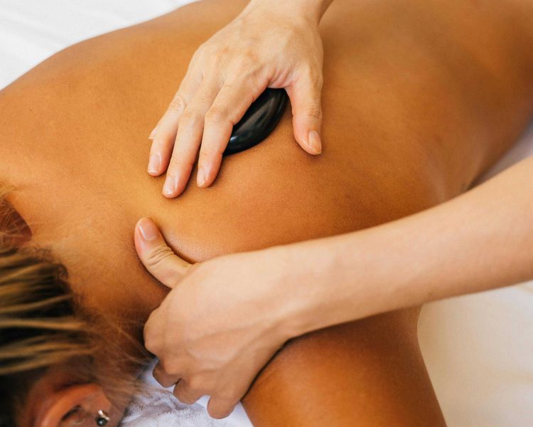 woman having a hot stone back massage treatment
