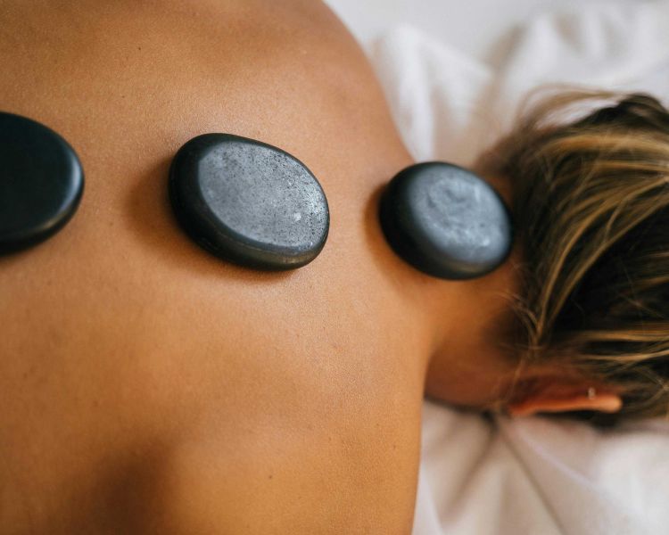 woman having a hot stone back massage treatment