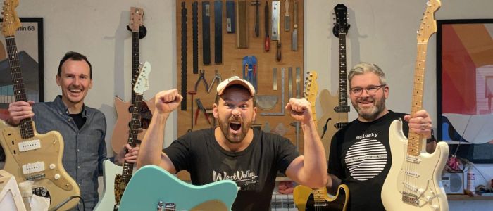 3 men holding guitars