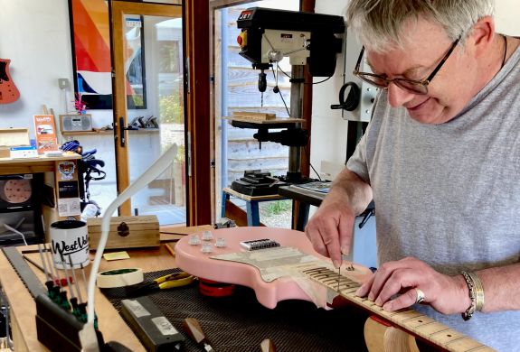 Man working on a guitar