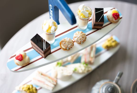afternoon tea displayed on a surfboard display stand for an afternoon tea at a hotel and spa in hampshire