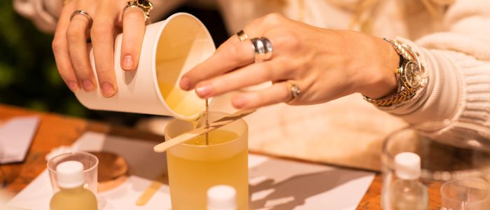woman pouring wax into a candle jar on an aromatherapy candle workshop in london