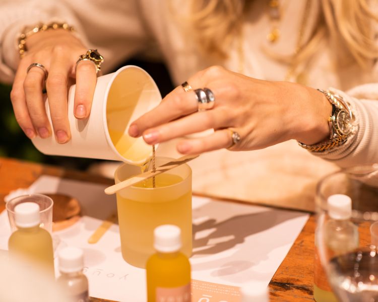 woman pouring wax into a candle jar on an aromatherapy candle workshop in london