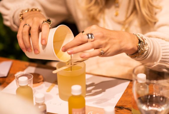 woman pouring wax into a candle jar on an aromatherapy candle workshop in london