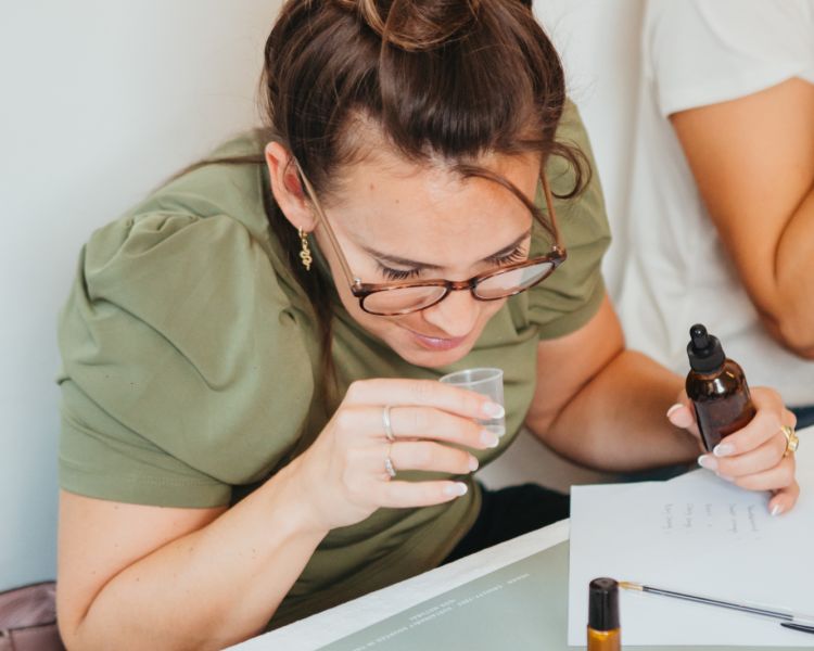 woman smelling essential oils on a perfume making workshop in london