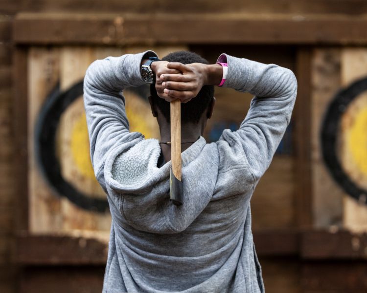 person aiming axe at target at go ape axe throwing experience